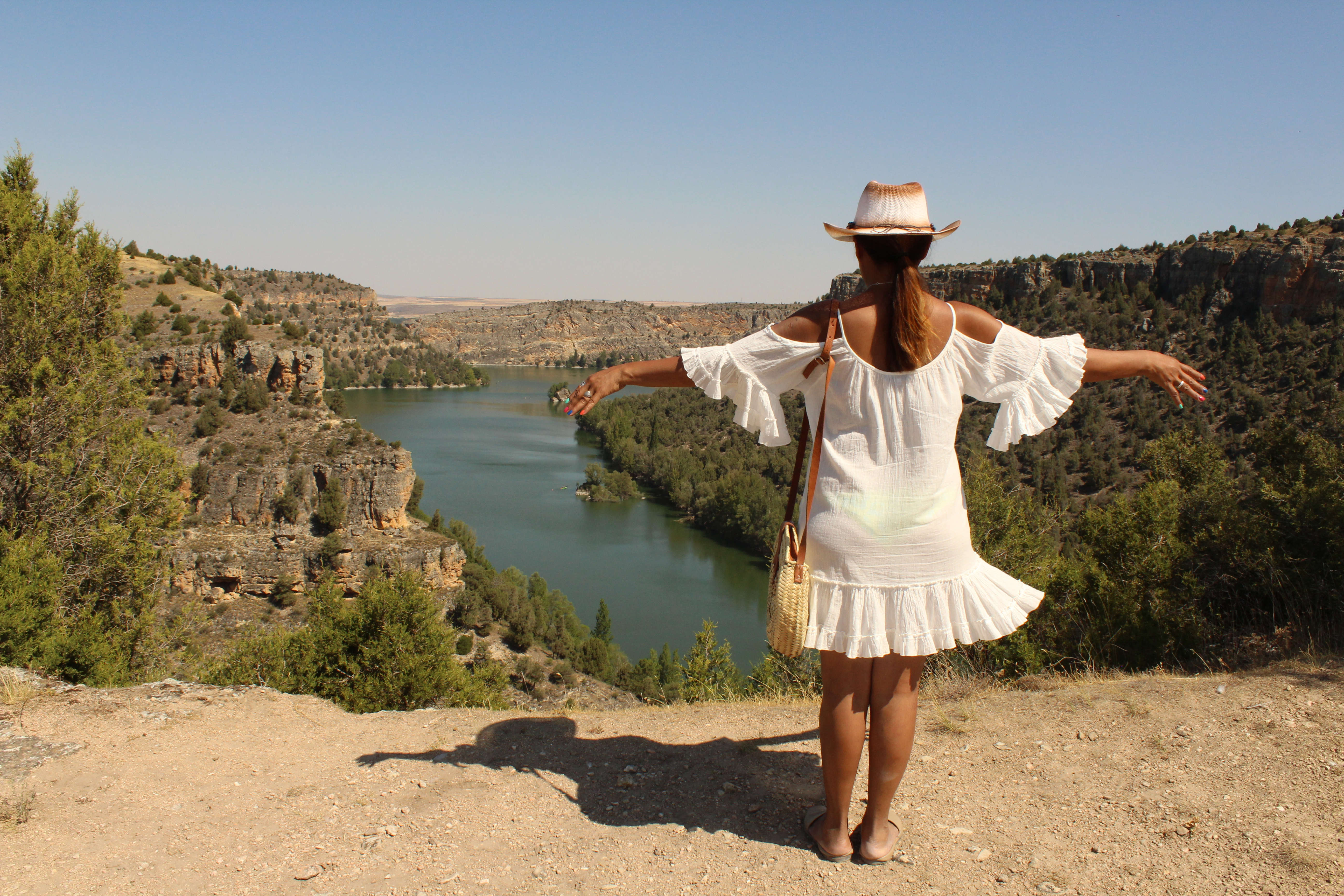 Chica de espalda con los brazos abiertos.